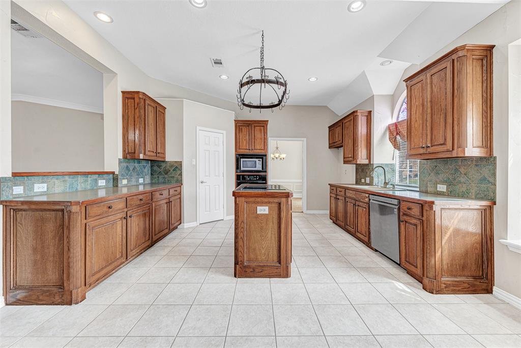 3500 Neiman Road Plano, TX 75025 - Photo 12 of 29 a large kitchen with granite countertop a stove a sink dishwasher and a refrigerator with wooden cabinets