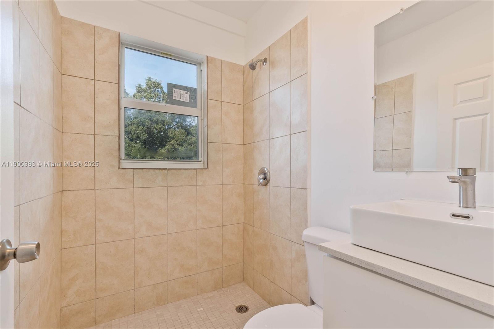 1051 Northwest 2nd Street, Unit 12 Miami, FL 33128 - Photo 8 of 14 a bathroom with a sink a toilet and shower