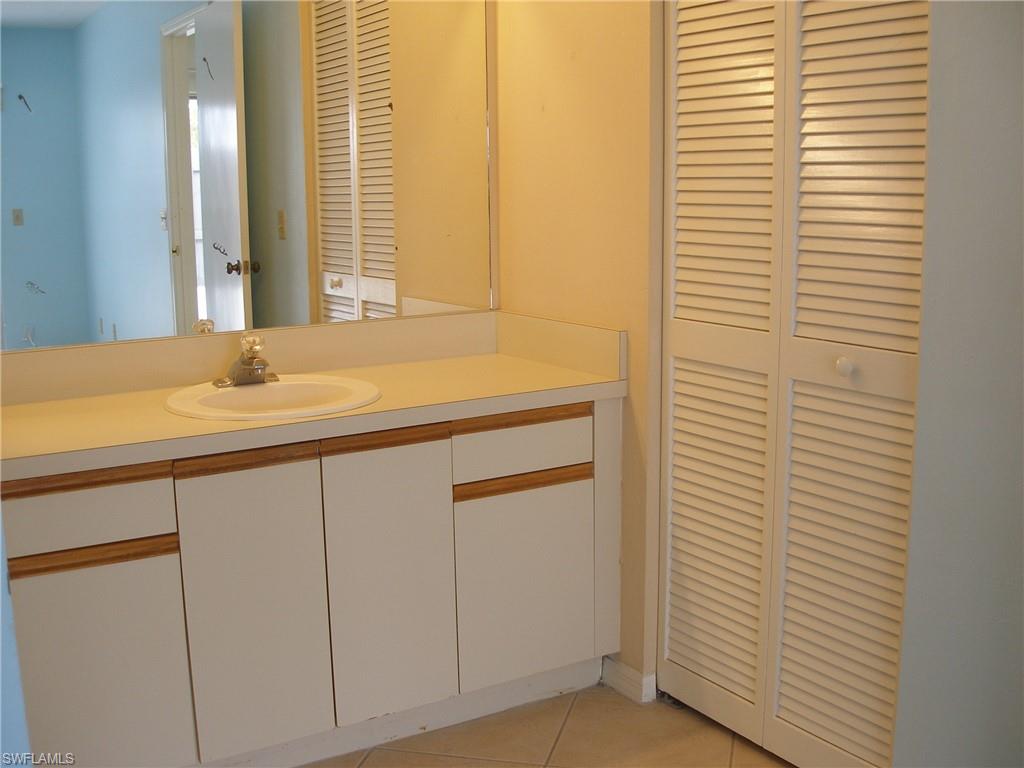 3342 Timberwood Circle Naples, FL 34105 - Photo 11 of 17 a bathroom with a sink and a mirror
