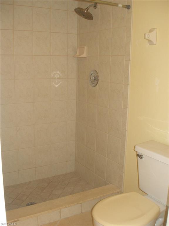 3342 Timberwood Circle Naples, FL 34105 - Photo 12 of 17 a white toilet sitting next to a bath tub