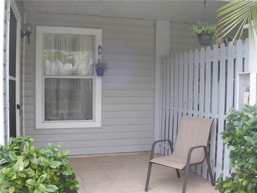 3342 Timberwood Circle Naples, FL 34105 - Photo 2 of 17 a view of a door and chair and table in the back yard of the house
