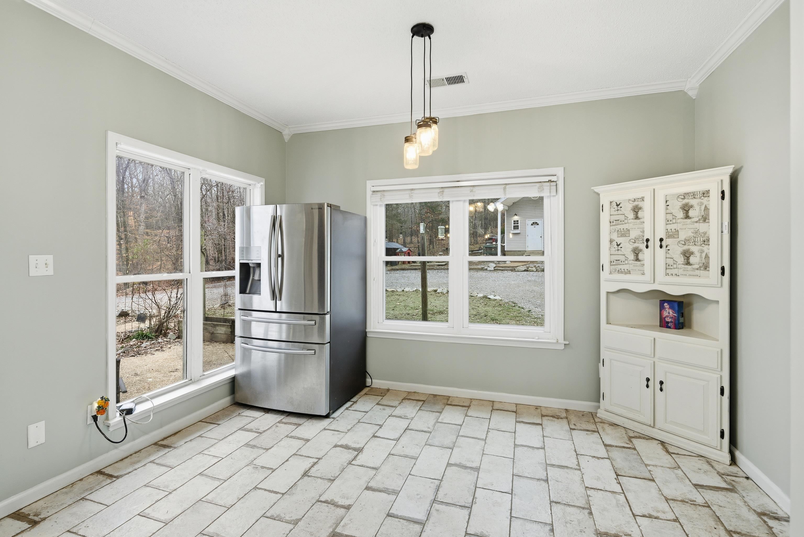 1755 Country Club Road Somerville, TN 38068 - Photo 24 of 40 Kitchen featuring stainless steel refrigerator with ice dispenser, crown molding, hanging light fixtures, white cabinets, and light countertops