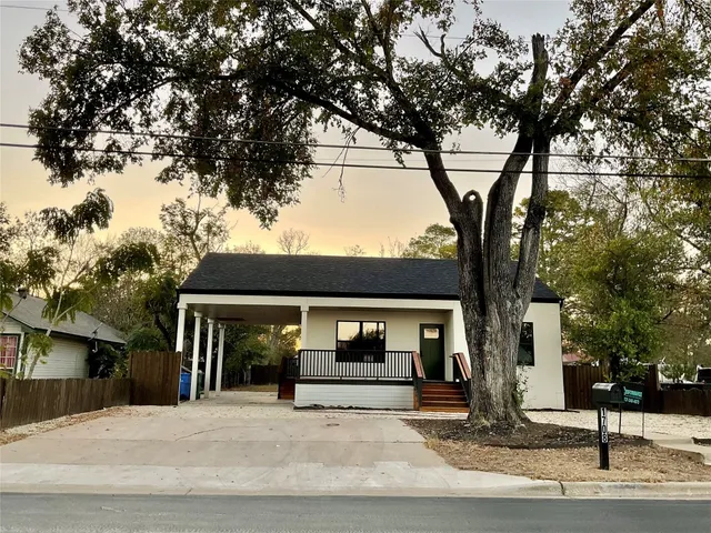 a front view of a house with a tree
