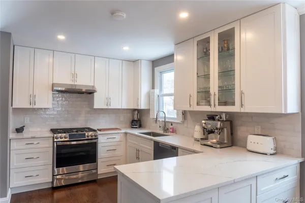 a kitchen with granite countertop white cabinets and white appliances