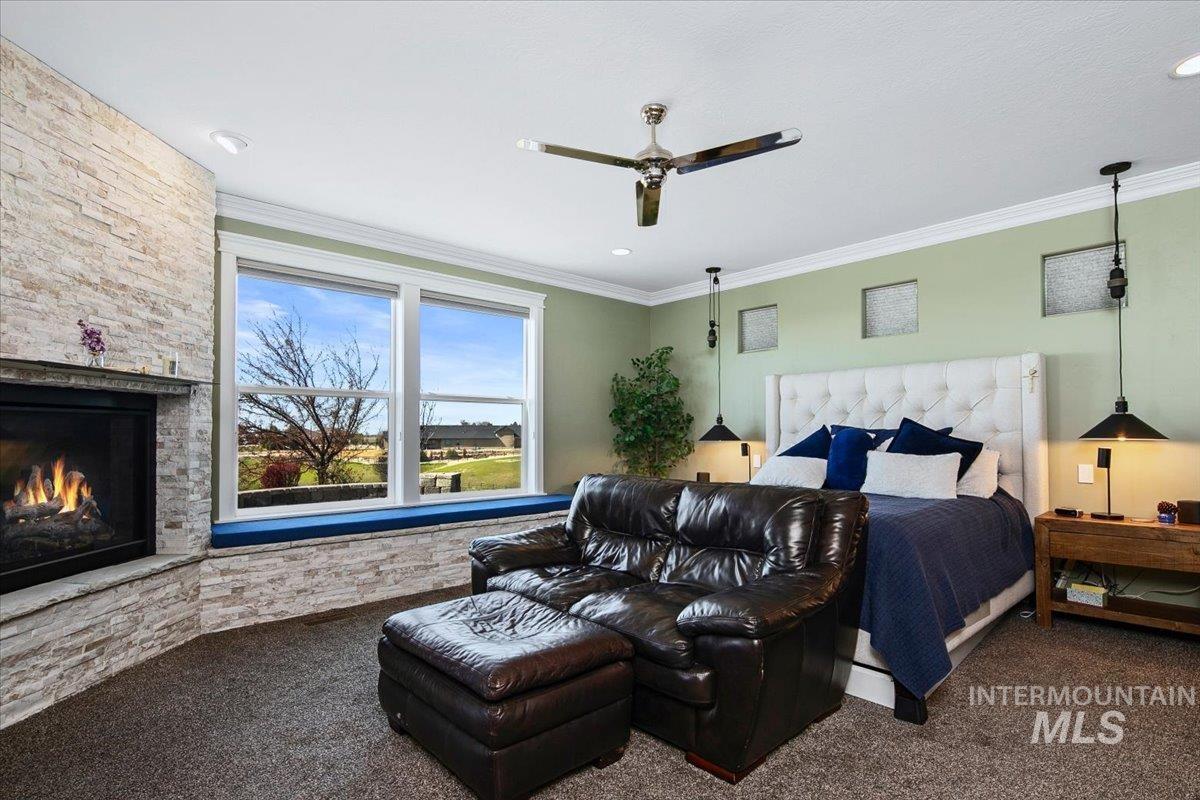 24053 Pheasant Ridge Court Middleton, ID 83644 - Photo 17 of 50 Carpeted bedroom featuring crown molding, a stone fireplace, and ceiling fan