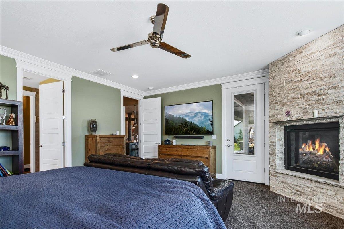 24053 Pheasant Ridge Court Middleton, ID 83644 - Photo 19 of 50 Bedroom with dark colored carpet, crown molding, a fireplace, ceiling fan, and recessed lighting