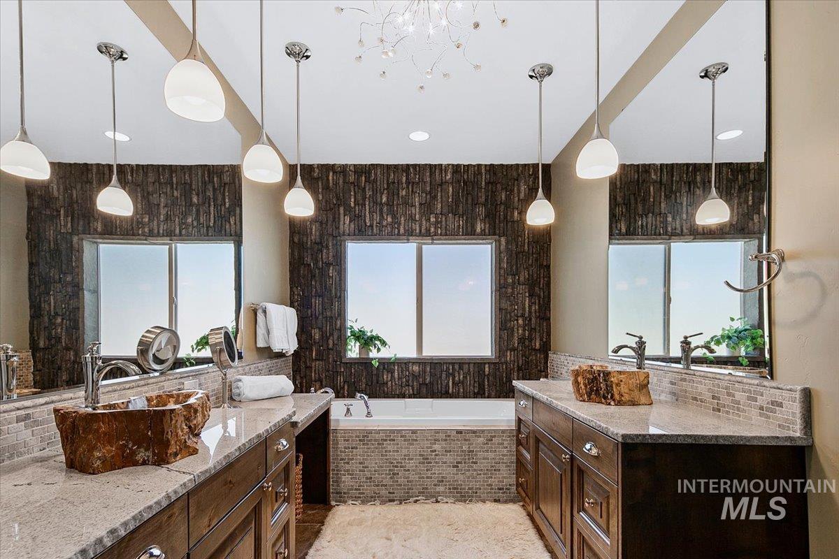 24053 Pheasant Ridge Court Middleton, ID 83644 - Photo 20 of 50 Bathroom with two vanities, a bath, and decorative backsplash