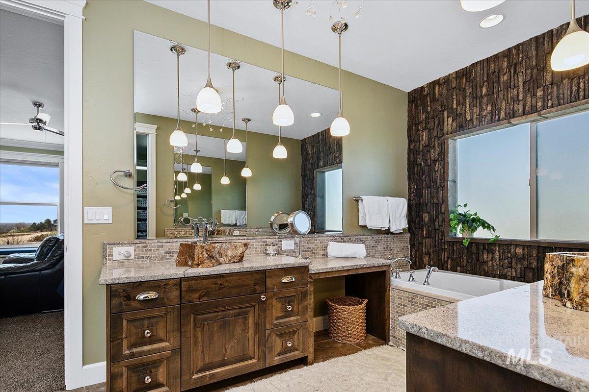 24053 Pheasant Ridge Court Middleton, ID 83644 - Photo 25 of 50 Ensuite bathroom with healthy amount of natural light, vanity, and a bath