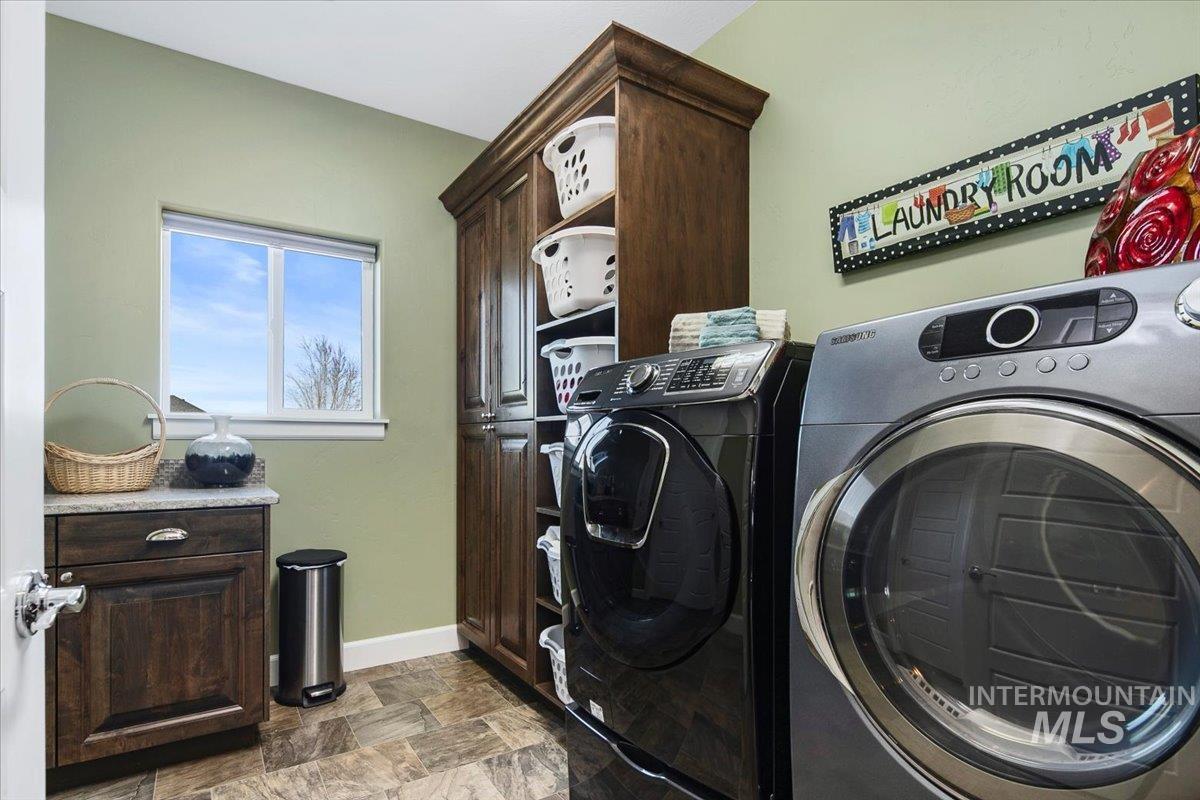 24053 Pheasant Ridge Court Middleton, ID 83644 - Photo 26 of 50 Laundry room featuring stone finish flooring, separate washer and dryer, and cabinet space
