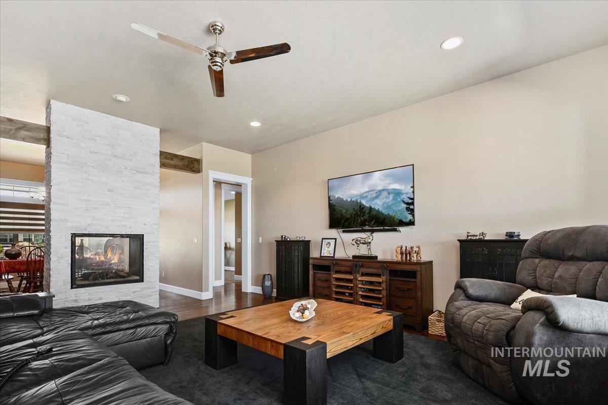 24053 Pheasant Ridge Court Middleton, ID 83644 - Photo 10 of 50 Living room featuring a ceiling fan, wood finished floors, and a fireplace