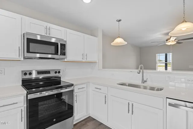 a kitchen with granite countertop a stove and a sink