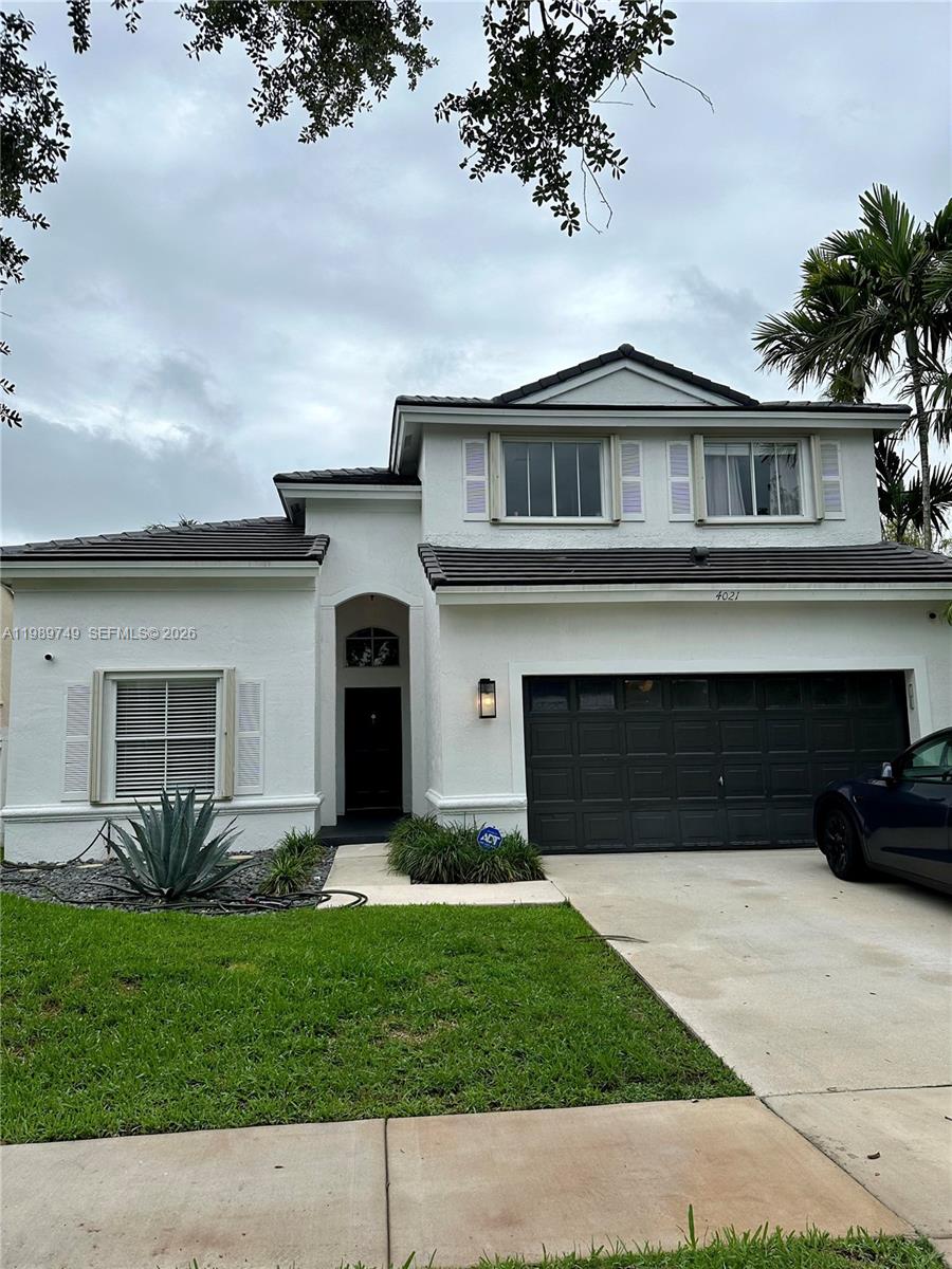 4021 Southwest 153rd Avenue Miramar, FL 33027 - Photo 20 of 42 a front view of a house with a yard and garage