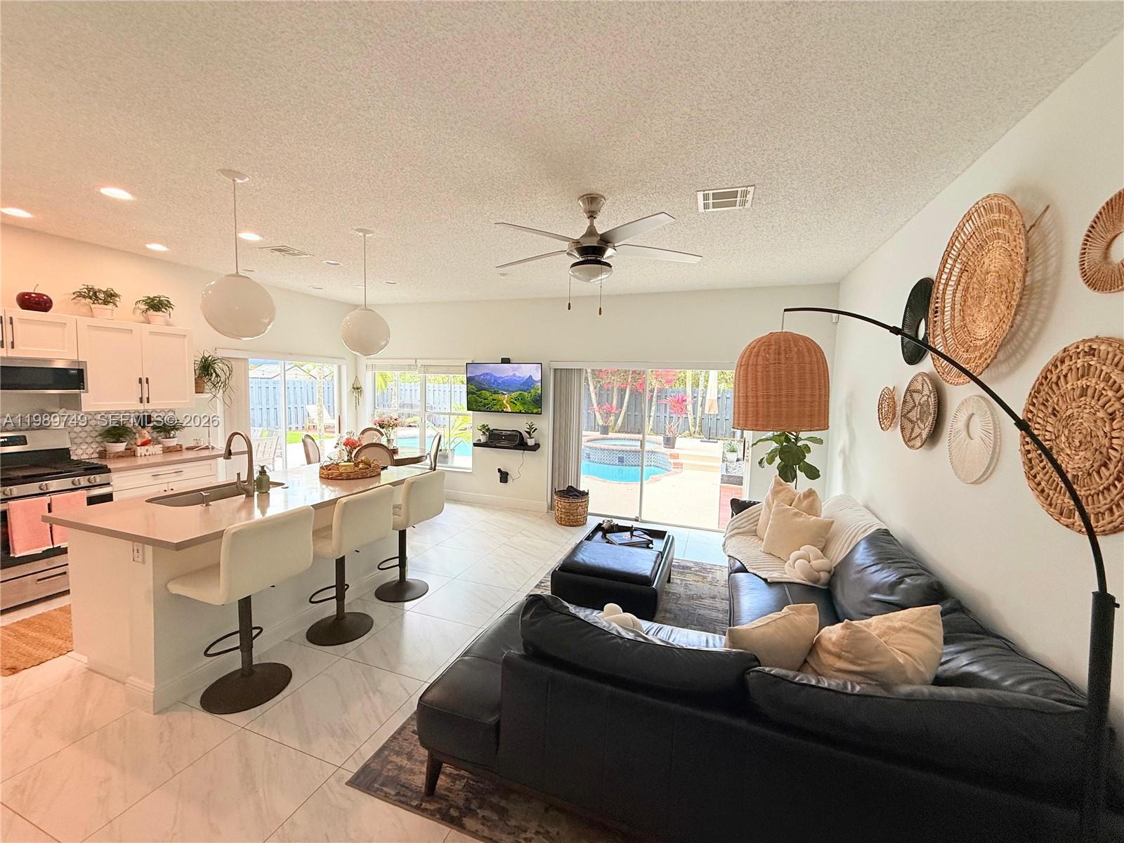 4021 Southwest 153rd Avenue Miramar, FL 33027 - Photo 21 of 42 a living room with furniture kitchen view and a chandelier