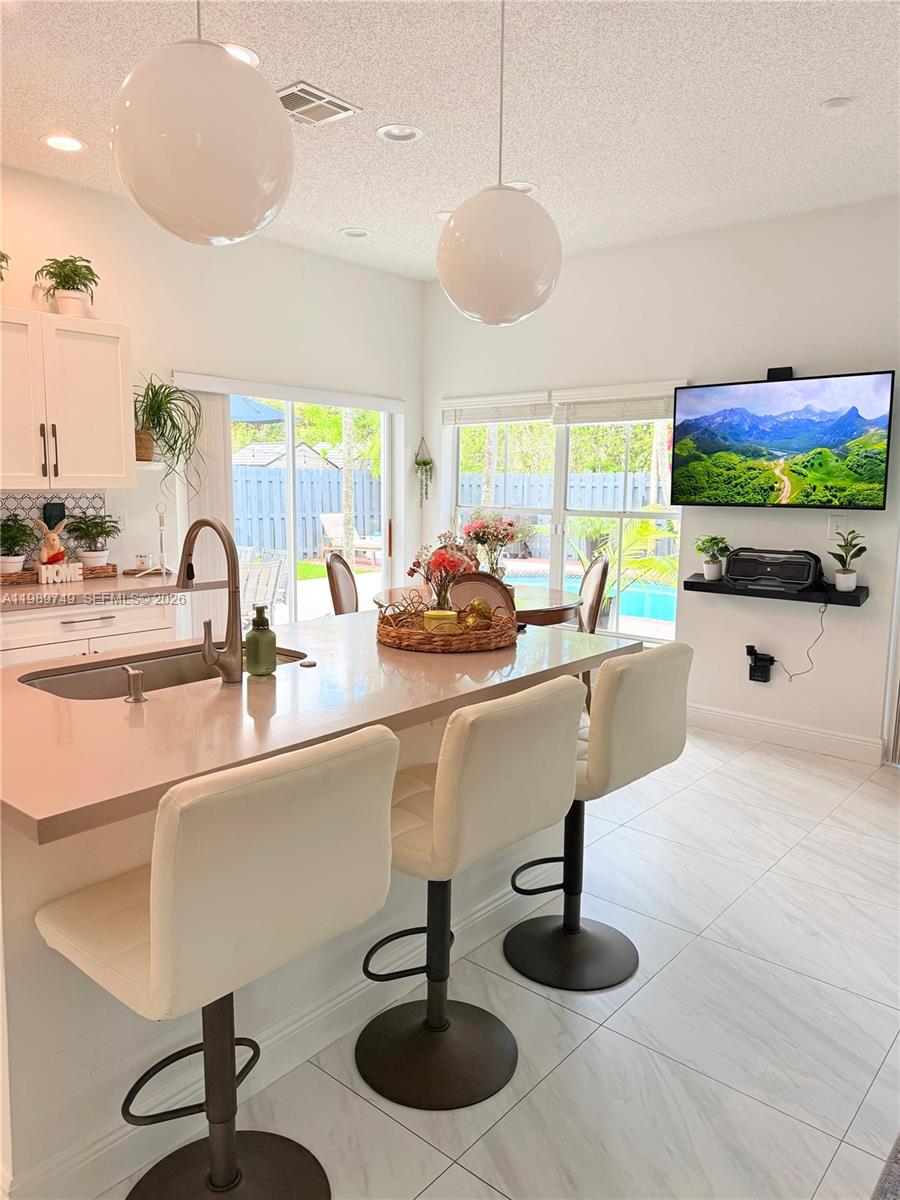 4021 Southwest 153rd Avenue Miramar, FL 33027 - Photo 22 of 42 a kitchen with a sink a counter and a view of living room