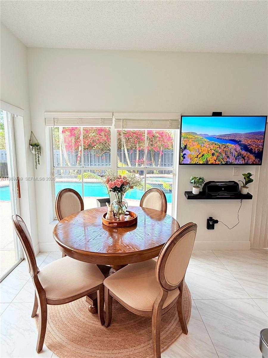 4021 Southwest 153rd Avenue Miramar, FL 33027 - Photo 23 of 42 a dining room with furniture and a floor to ceiling window
