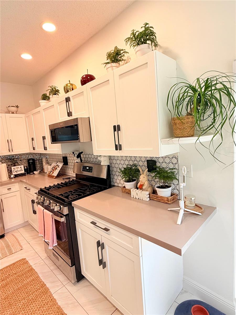 4021 Southwest 153rd Avenue Miramar, FL 33027 - Photo 27 of 42 a kitchen with a sink a stove and chairs