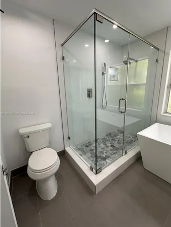 a bathroom with a toilet and a shower