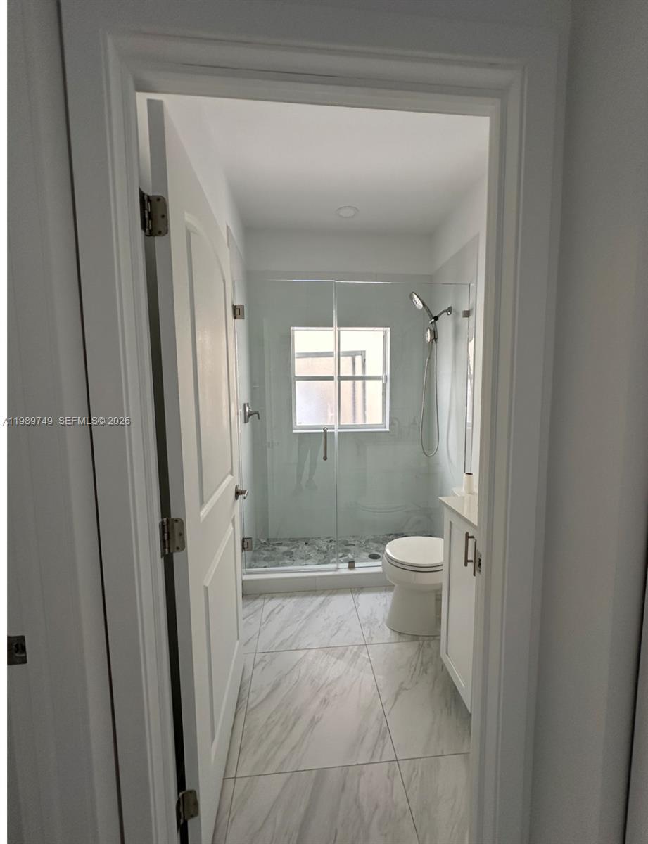 4021 Southwest 153rd Avenue Miramar, FL 33027 - Photo 9 of 42 a bathroom with a granite countertop shower a toilet and a window