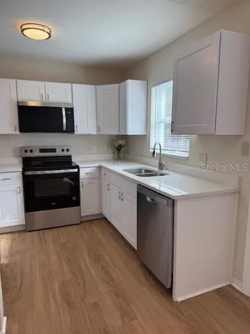 a kitchen with stainless steel appliances a refrigerator sink and microwave