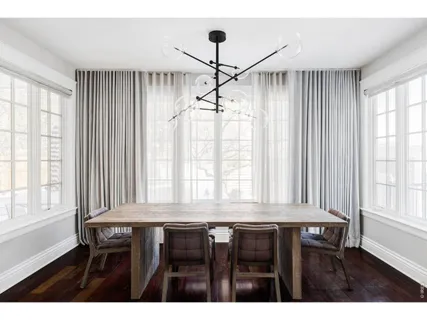 a dining room with wooden floor and windows