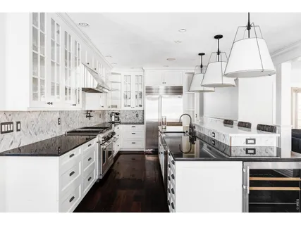 a kitchen with stainless steel appliances granite countertop a stove and white cabinets