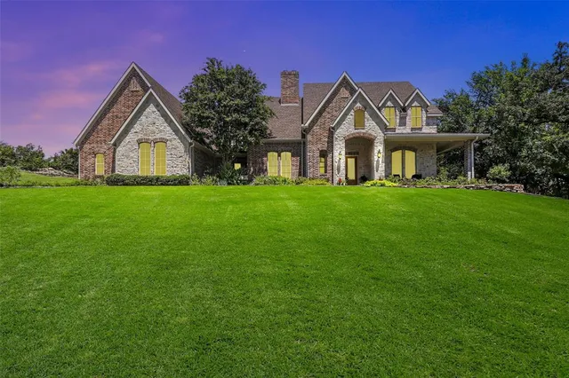 a view of a house with a big yard and large trees