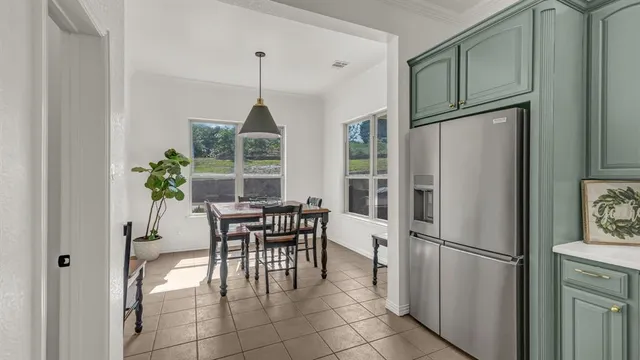a kitchen with stainless steel appliances a refrigerator a table and chairs