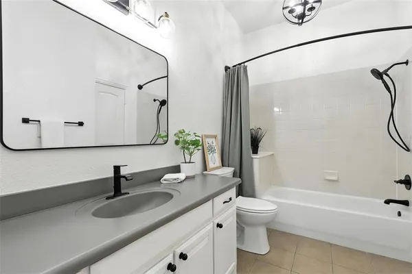 a bathroom with a granite countertop sink a toilet and bathtub