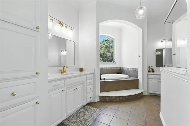 a bathroom with a tub sink and mirror