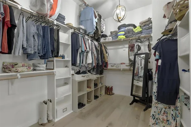 a view of walk in closet with clothes