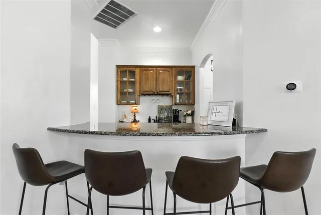 a kitchen with granite countertop white cabinets and chairs