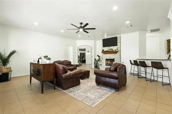a living room with furniture ceiling fan and a flat screen tv