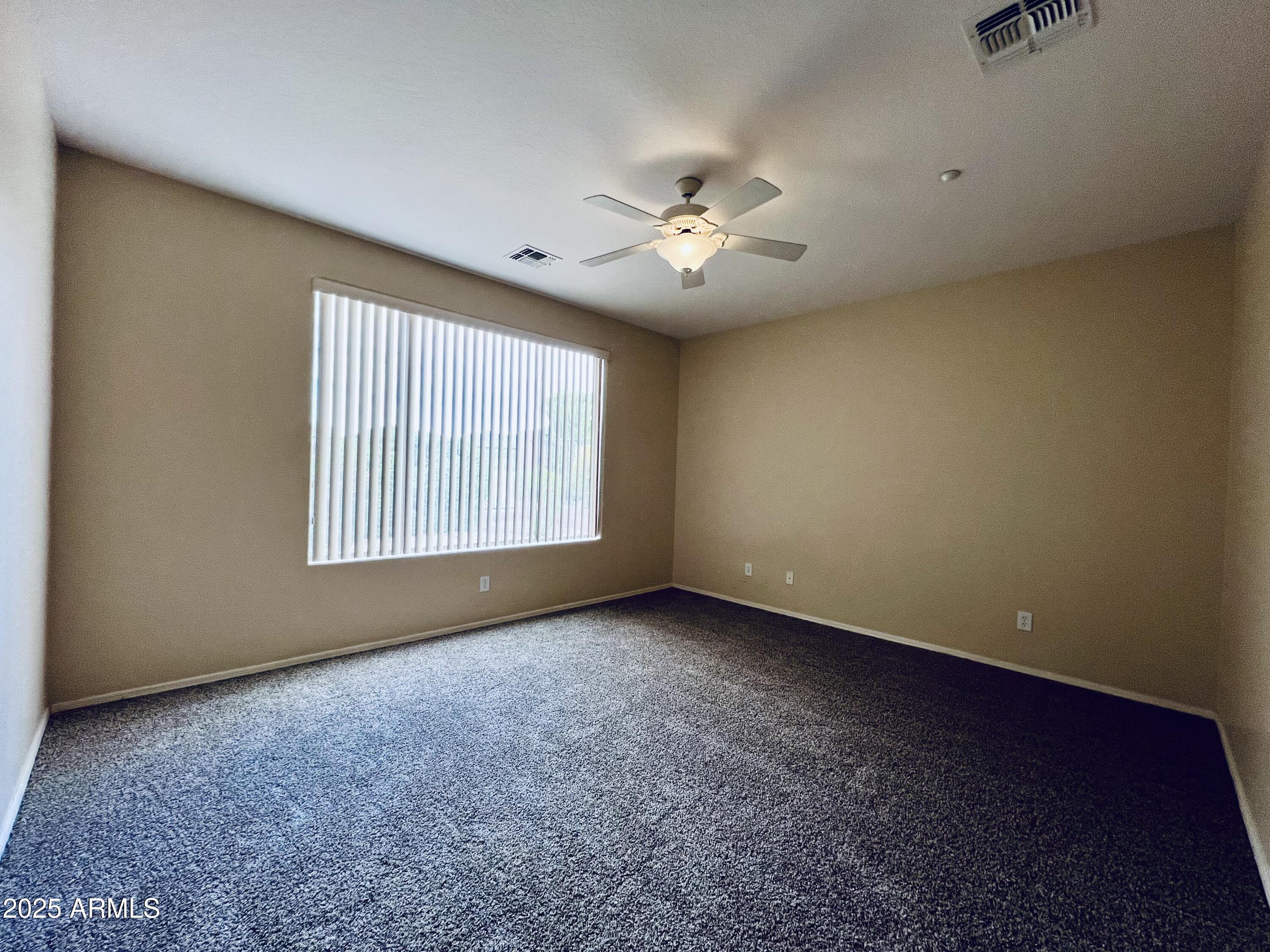 41018 North Prestancia Way Anthem, AZ 85086 - Photo 4 of 29 an empty room with windows and ceiling fan