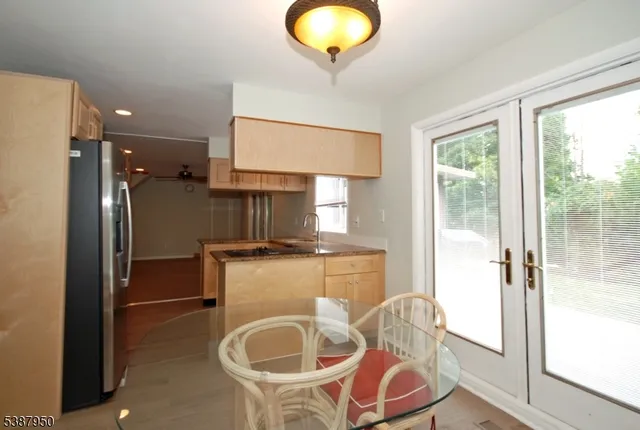 a kitchen with kitchen island a stove a refrigerator and a sink