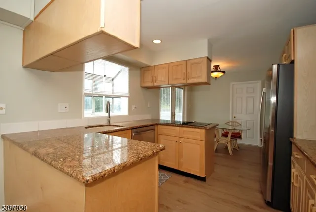 a kitchen with a stove a sink and chairs