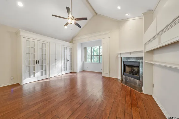 a view of an empty room with a window and wooden floor