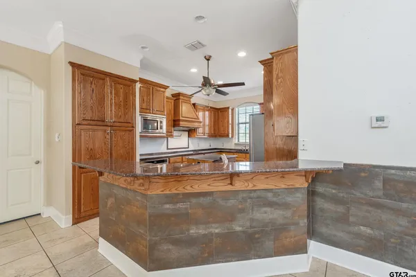 a view of a living room with kitchen island granite countertop furniture and a fireplace