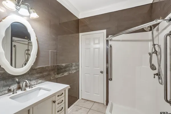 a bathroom with a double vanity sink mirror and shower