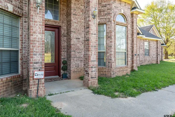 front view of a brick house with a yard