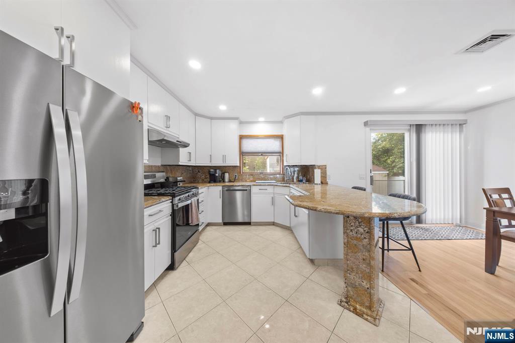 62 Sycamore Road Dumont, NJ 07628 - Photo 11 of 43 a kitchen with white cabinets and stainless steel appliances