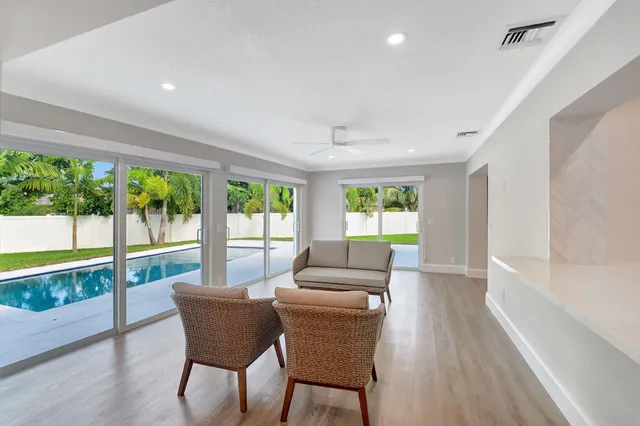 a dining room with furniture large windows and wooden floor
