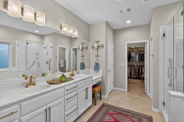 a spacious bathroom with a double vanity sink a mirror and shower