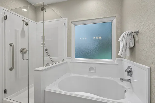 a white bath tub sitting next to a shower