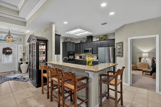 a kitchen with stainless steel appliances kitchen island granite countertop a table and chairs in it