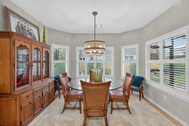 a dining room with furniture a chandelier and wooden floor