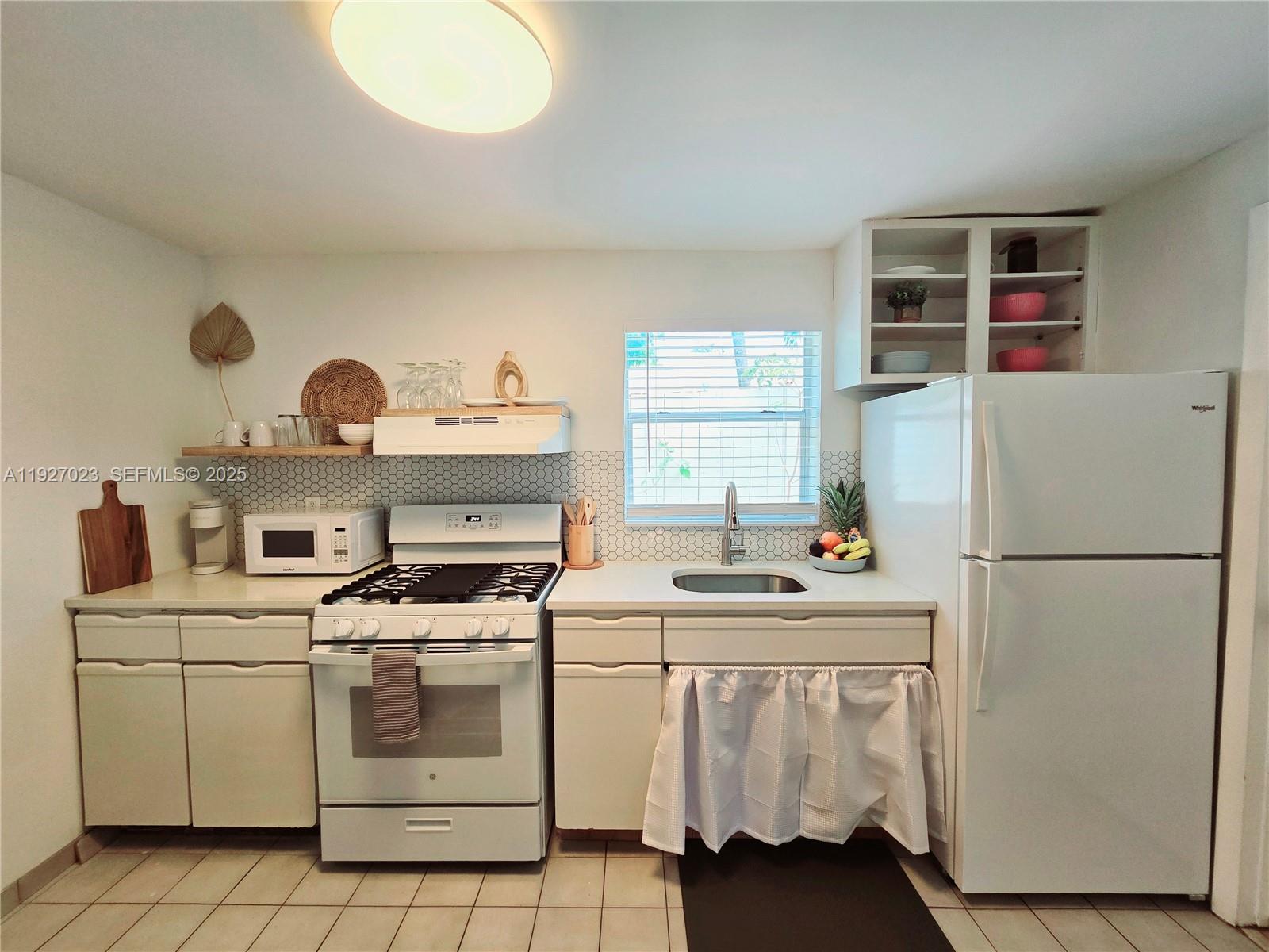 1872 Southwest 9th Street Miami, FL 33135 - Photo 34 of 48 a white kitchen with a stove a refrigerator and a sink