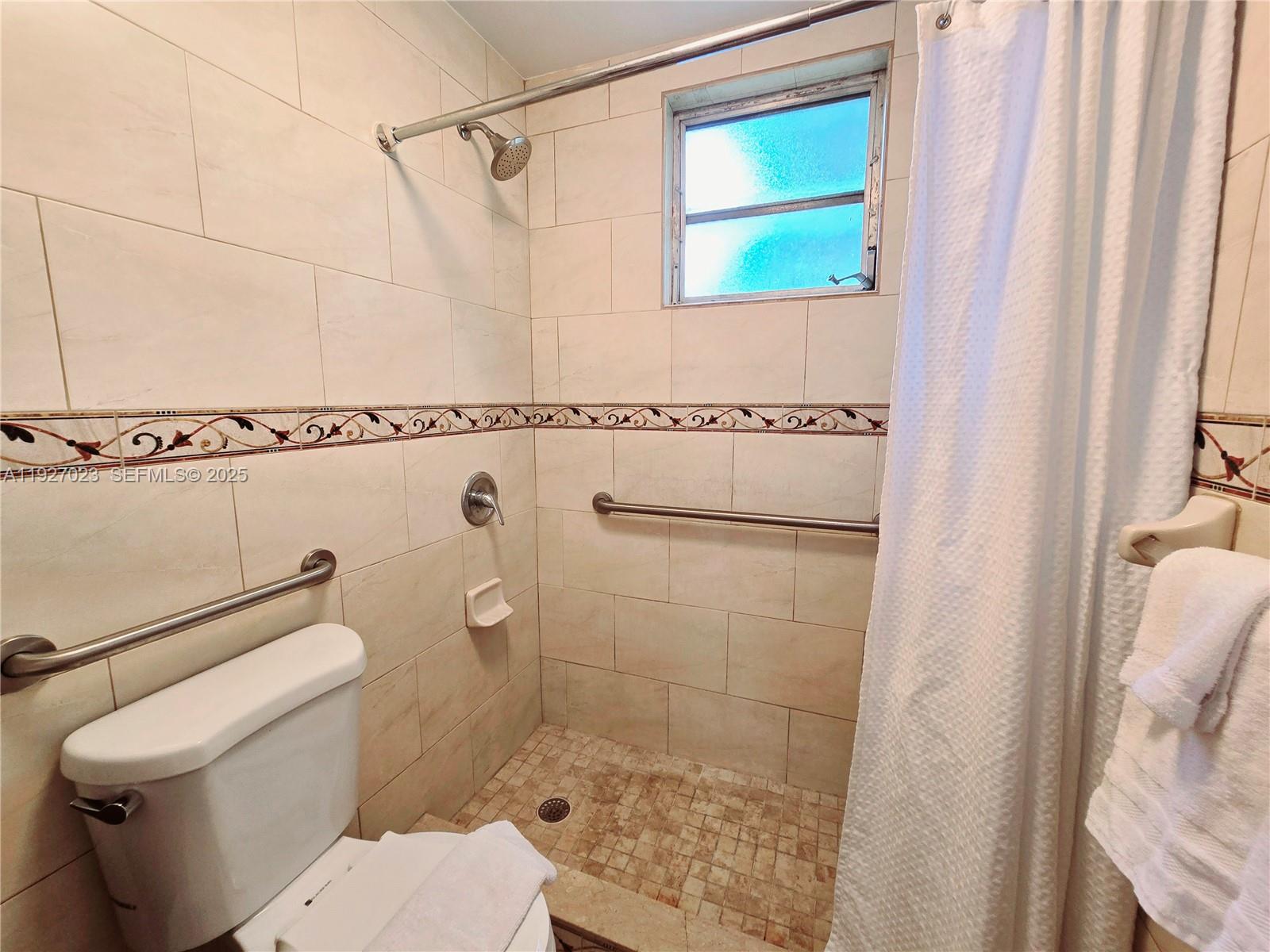 1872 Southwest 9th Street Miami, FL 33135 - Photo 40 of 48 a bathroom with a shower a toilet and a window