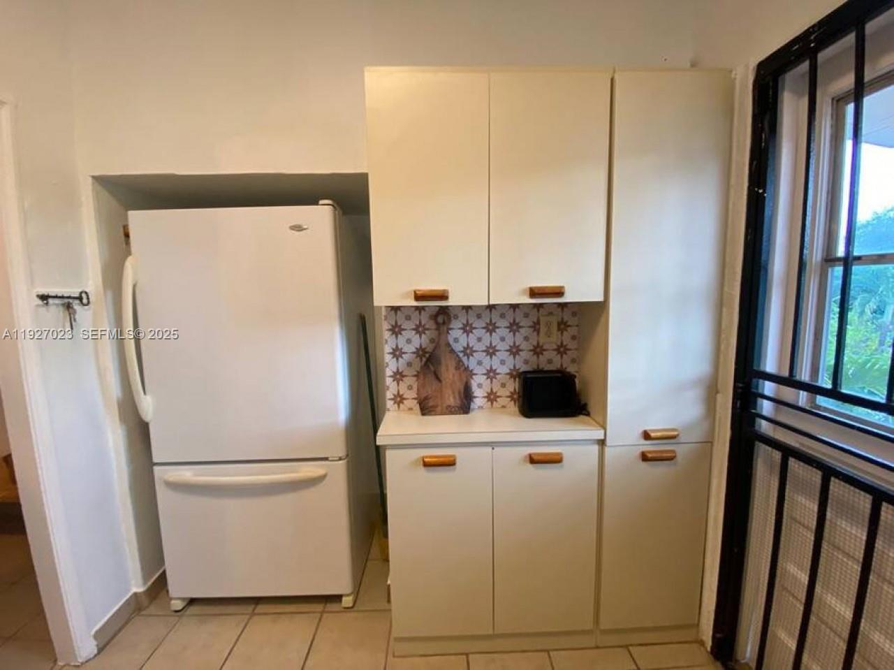 1872 Southwest 9th Street Miami, FL 33135 - Photo 10 of 48 a white refrigerator freezer and a table in a kitchen