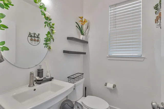 a bathroom with a sink and mirror with toilet