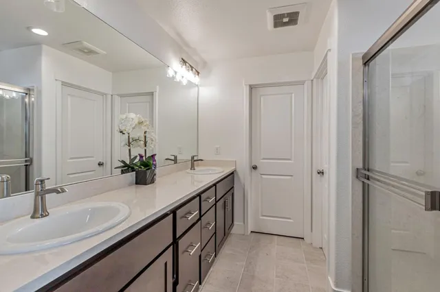 a bathroom with a double vanity sink and a mirror